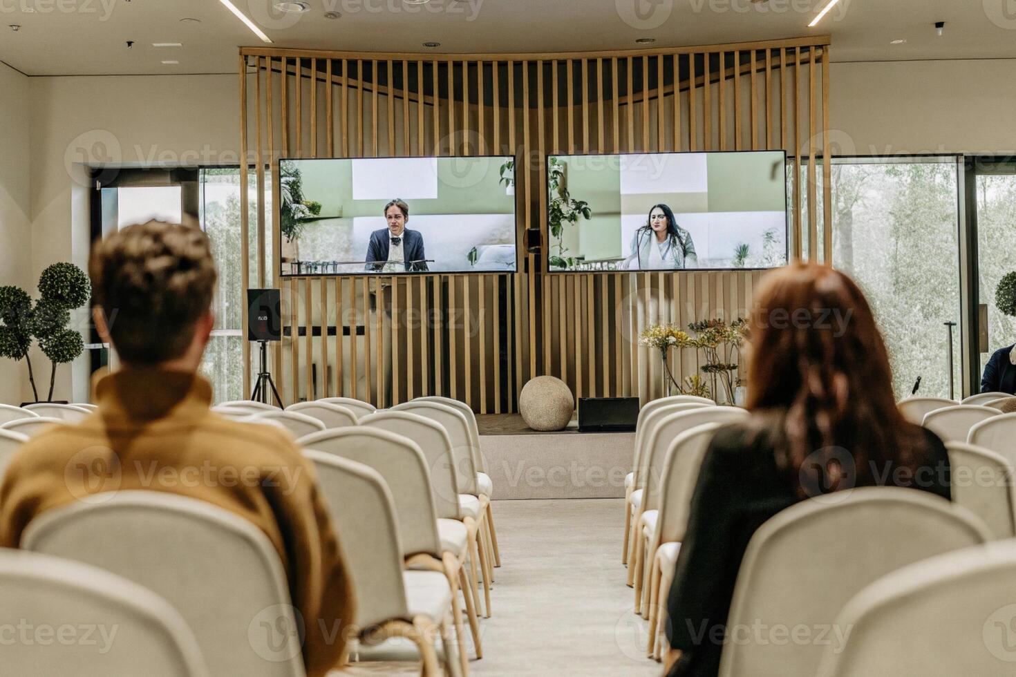 Back View Of Audience In The Modern Conference Hall Or Seminar Meeting With Large Media Screen Showing Presentation Of Business photo