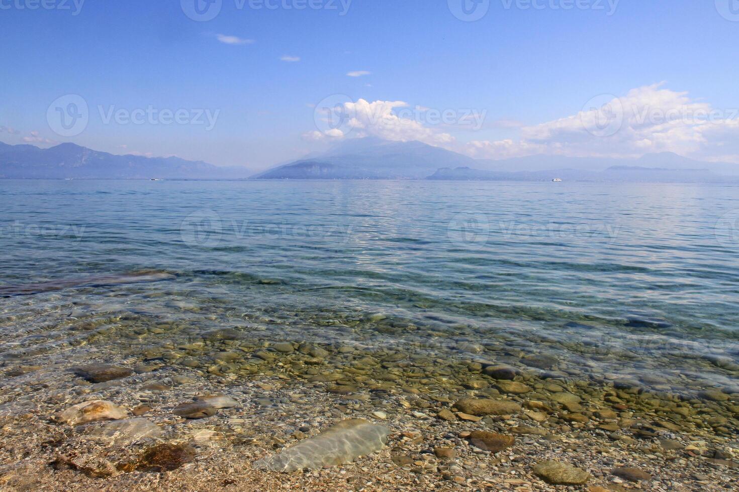 Picturesque view of a clear lake with mountains in the background. photo