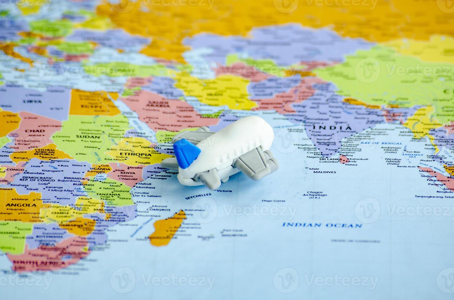 Small airplane placed on a world map representing travel or global exploration photo