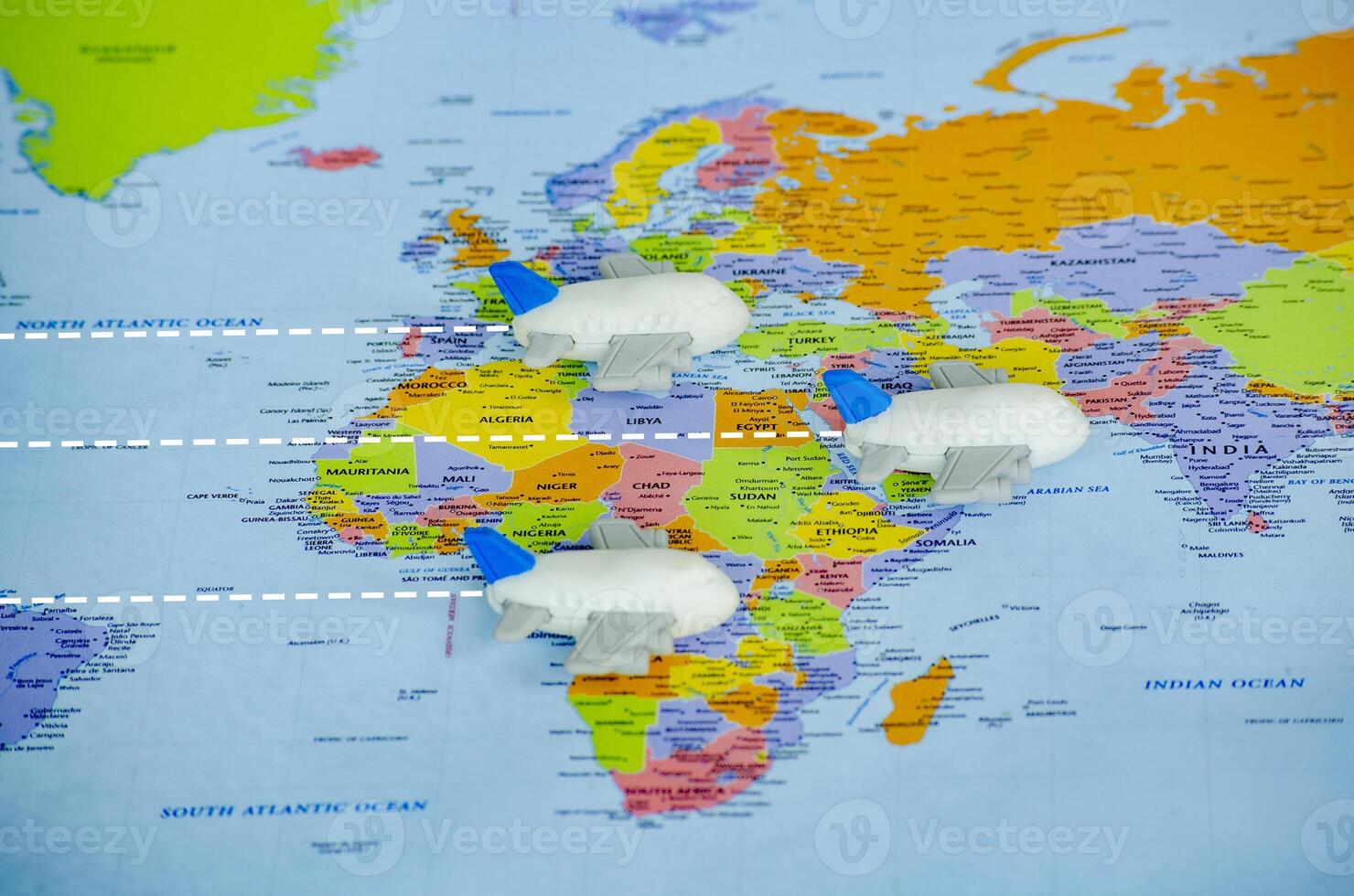 Small toy airplanes on world map representing travel or global exploration. Travel and destination concept photo