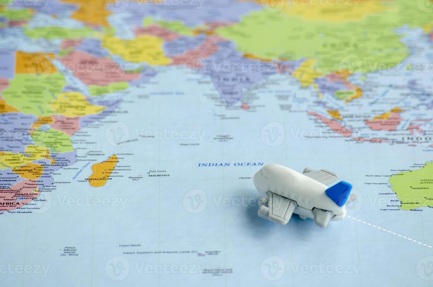 Small airplane placed on a world map heading to its destination. Travel and exploration concept. photo