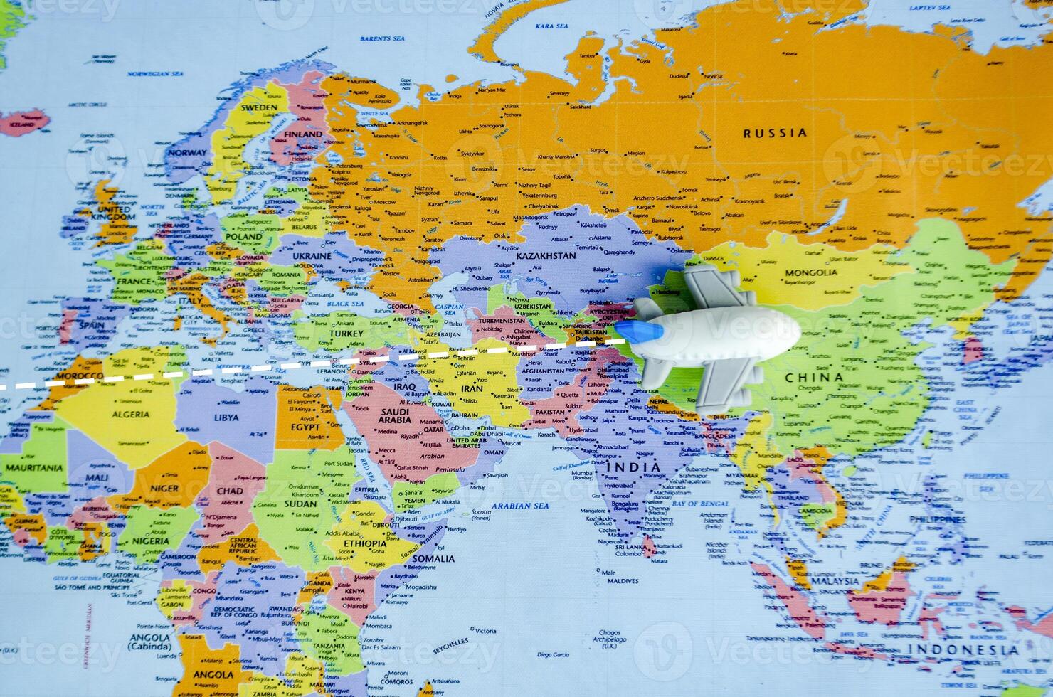 Top view of small toy airplane on a world map representing travel and destination concept photo