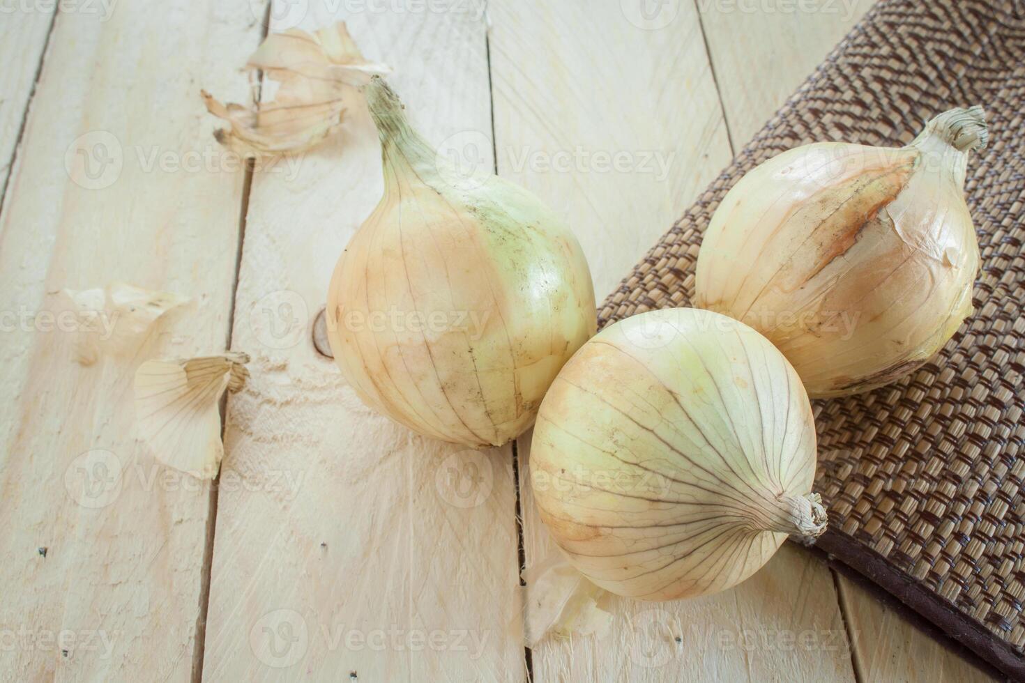 three onions on wooden table photo