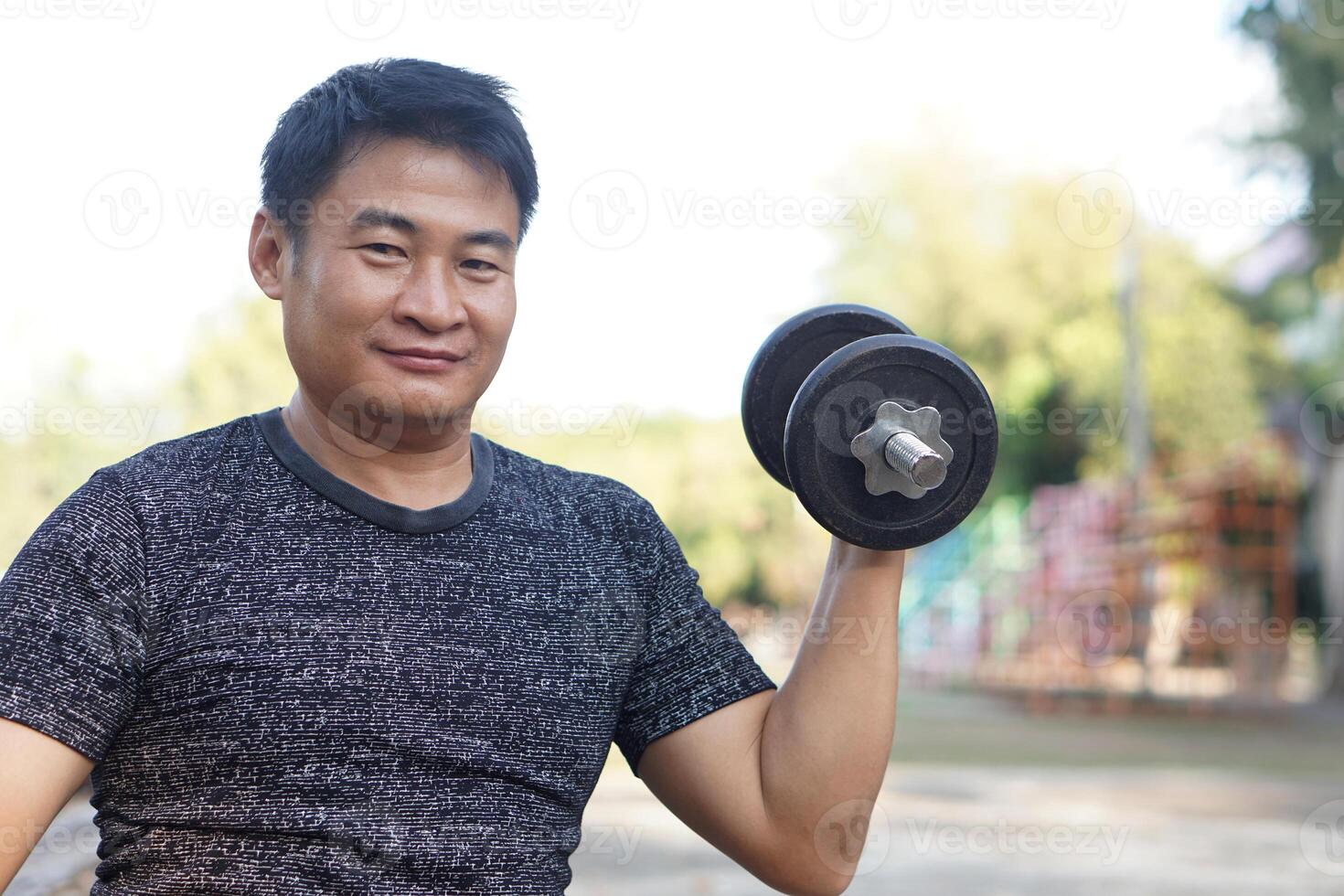 Asian man exercises outdoor, lift dumbbell. Concept, Exercise for health bodybuilding. Strengthen muscle. Weight lifting. Healthy lifestyle. Sport equipment. Work out makes strong of body. photo