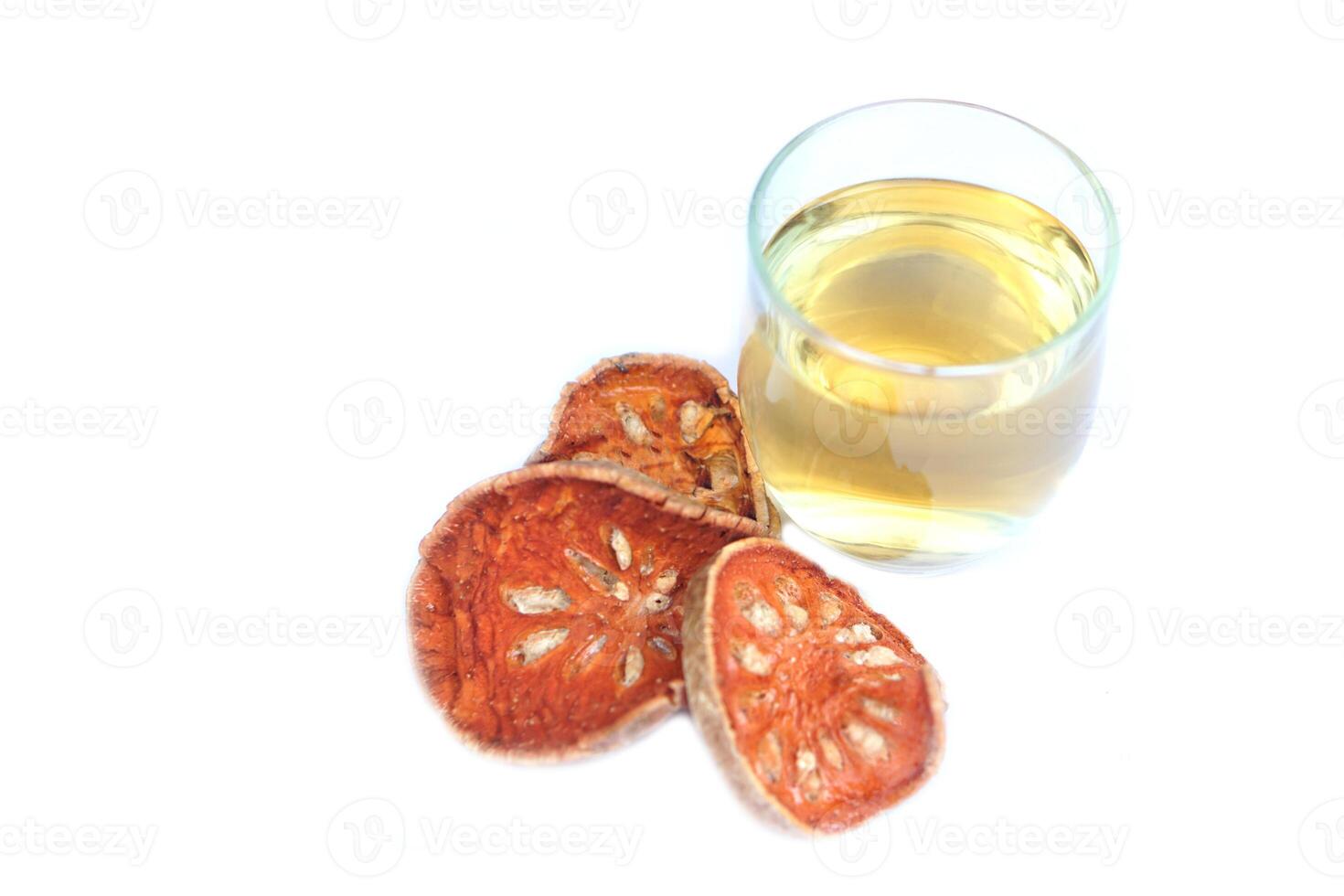 Bael fruit herbal drink in clear glass. Concept healthy drink with medicinal property, made from dried sliced bael, boiled in water, can drink as hot tea or iced beverage. photo