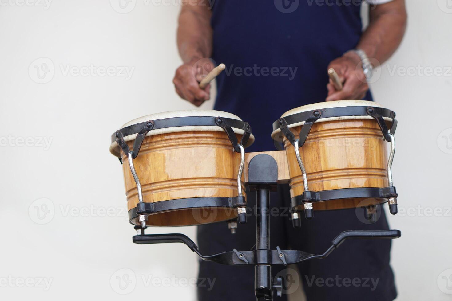 Man is beating the bongo drums. Concept, musical percussion instrument for rhythm of music to make more fun for performing or dancing. Beat drum with rhythm along music and songs. photo