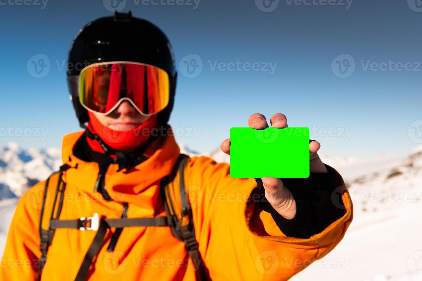 Ski pass with copy space in hand of skier with mountain range in background. Concept for illustration of entrance fee for winter sport photo