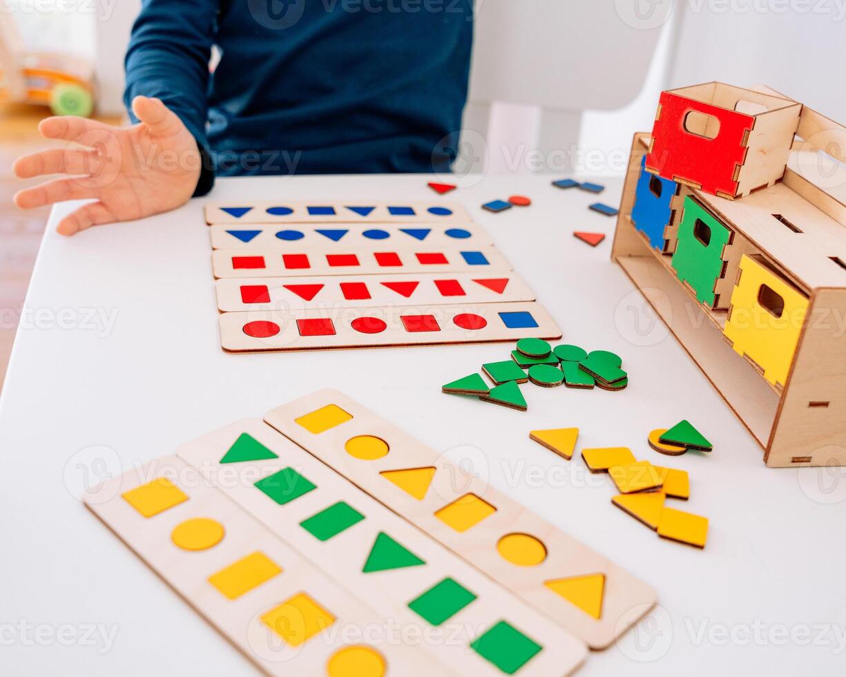 The shapes are scattered across the table, offering a hands-on Montessori learning experience. photo