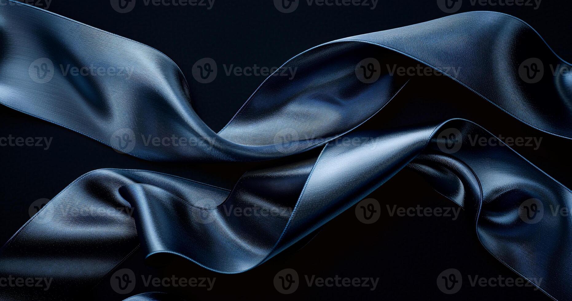 Fluid, dark navy satin ribbons on a black background. Detailed folds and drapes showcase rich texture photo