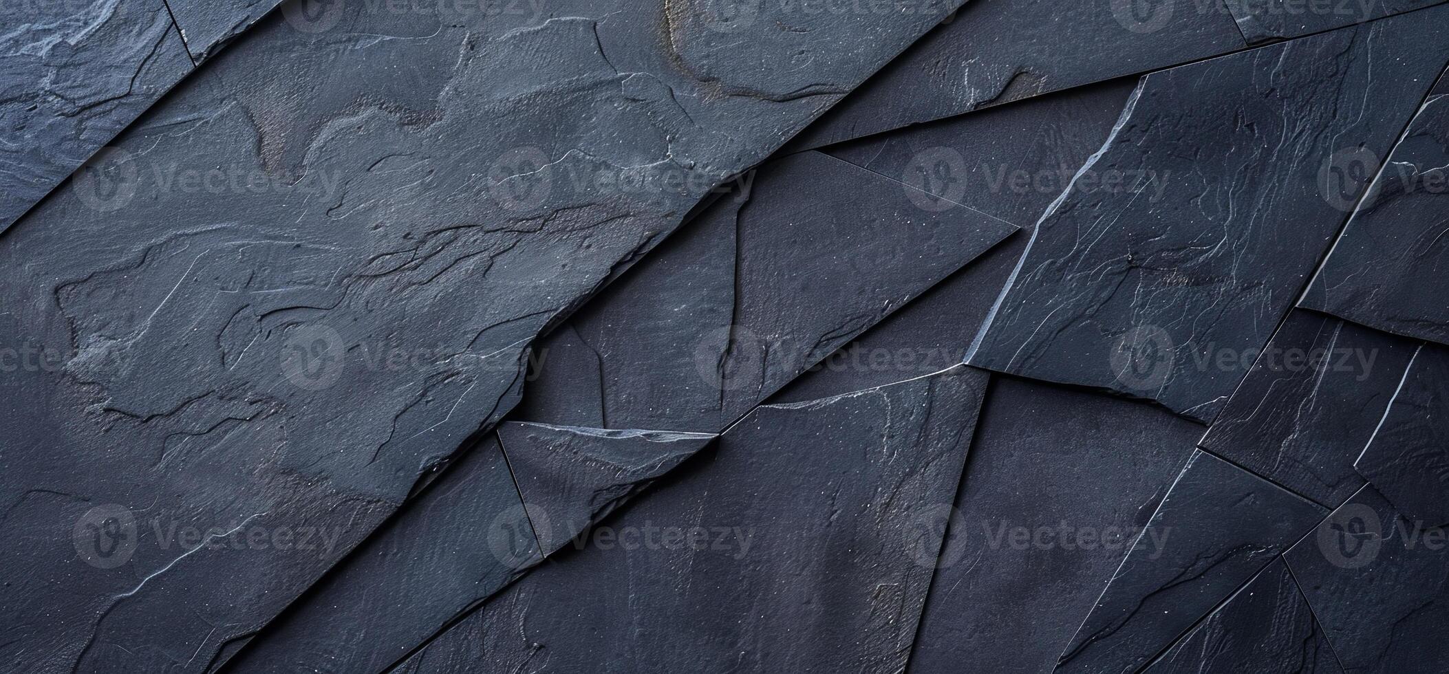 A black stone wall with a pattern of different shapes photo