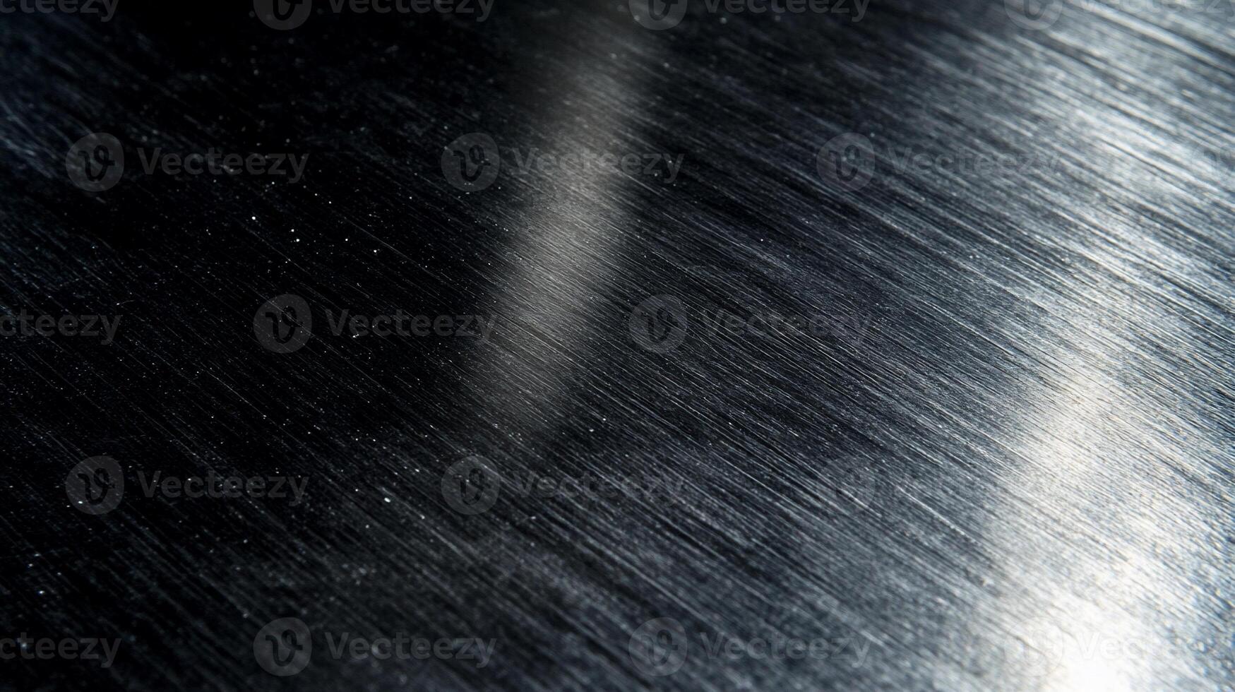 Dark, brushed metal surface with light reflections photo