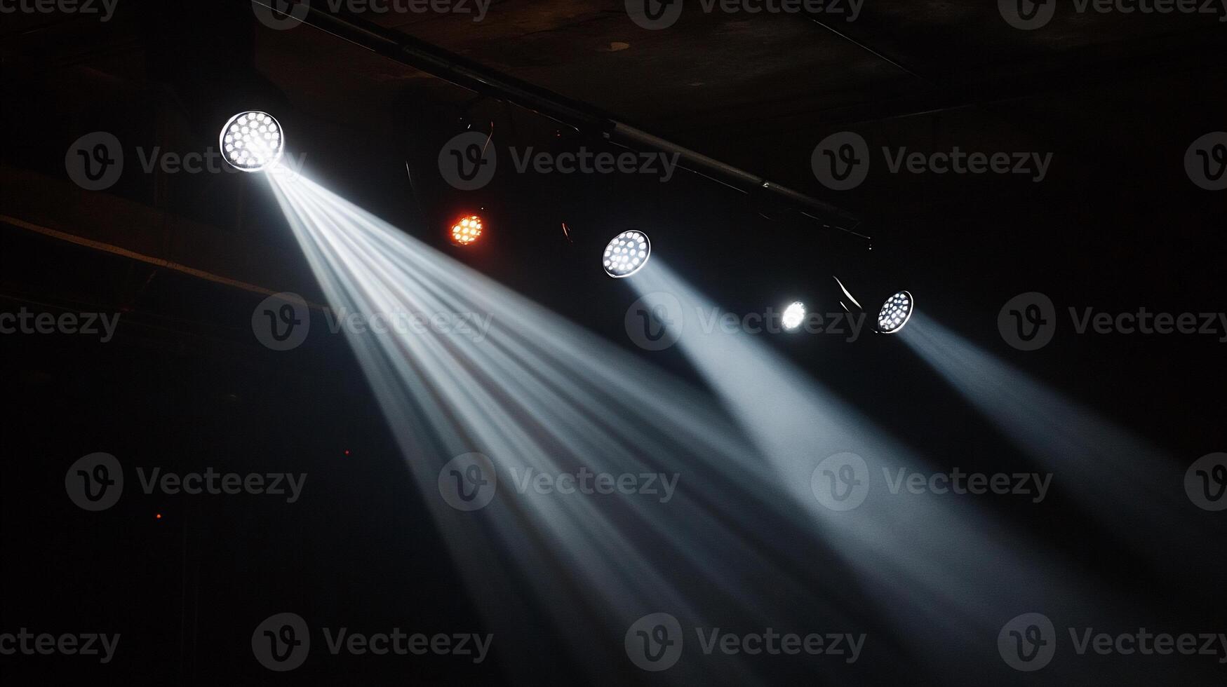 Stage lights illuminating dark room photo