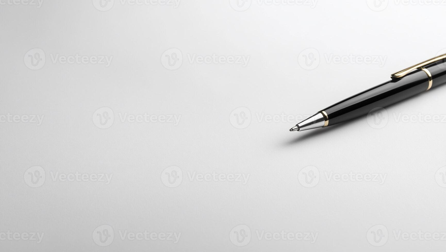Close-up of a black ballpoint pen on a white surface photo