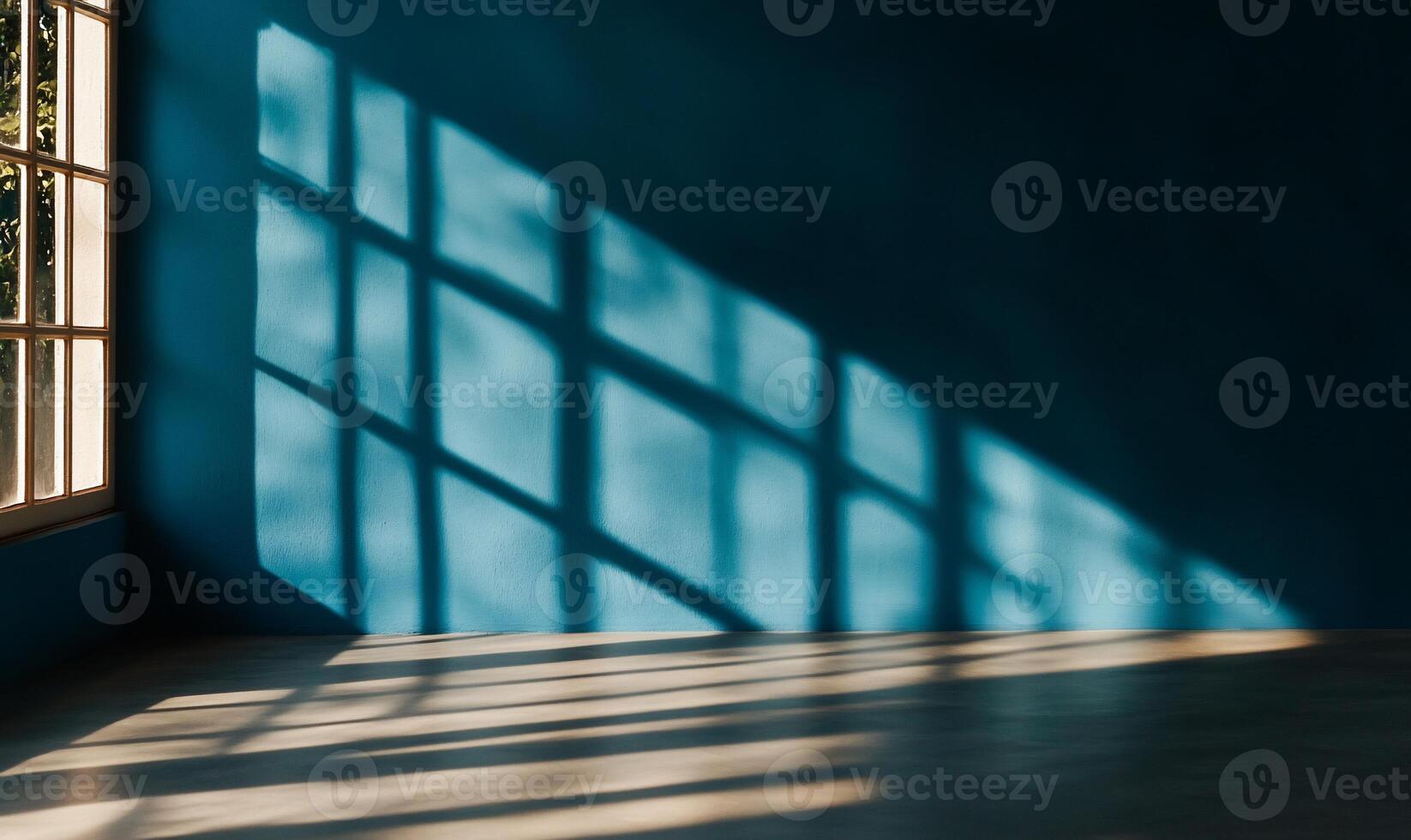 Sunlight casts shadows on a teal wall through a window photo