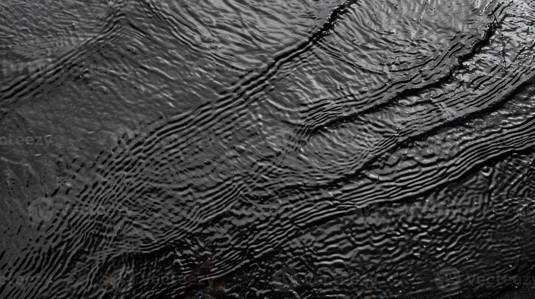 Dark, textured water surface with subtle wave patterns photo