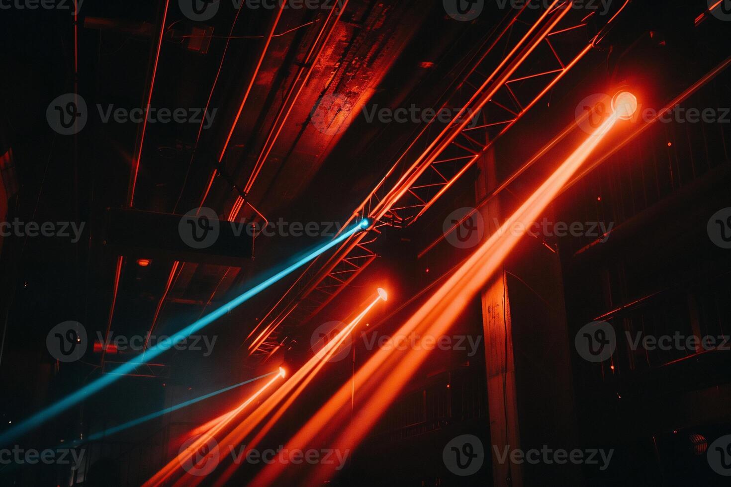 Stage lights illuminating dark venue. Red and blue beams crisscrossing photo