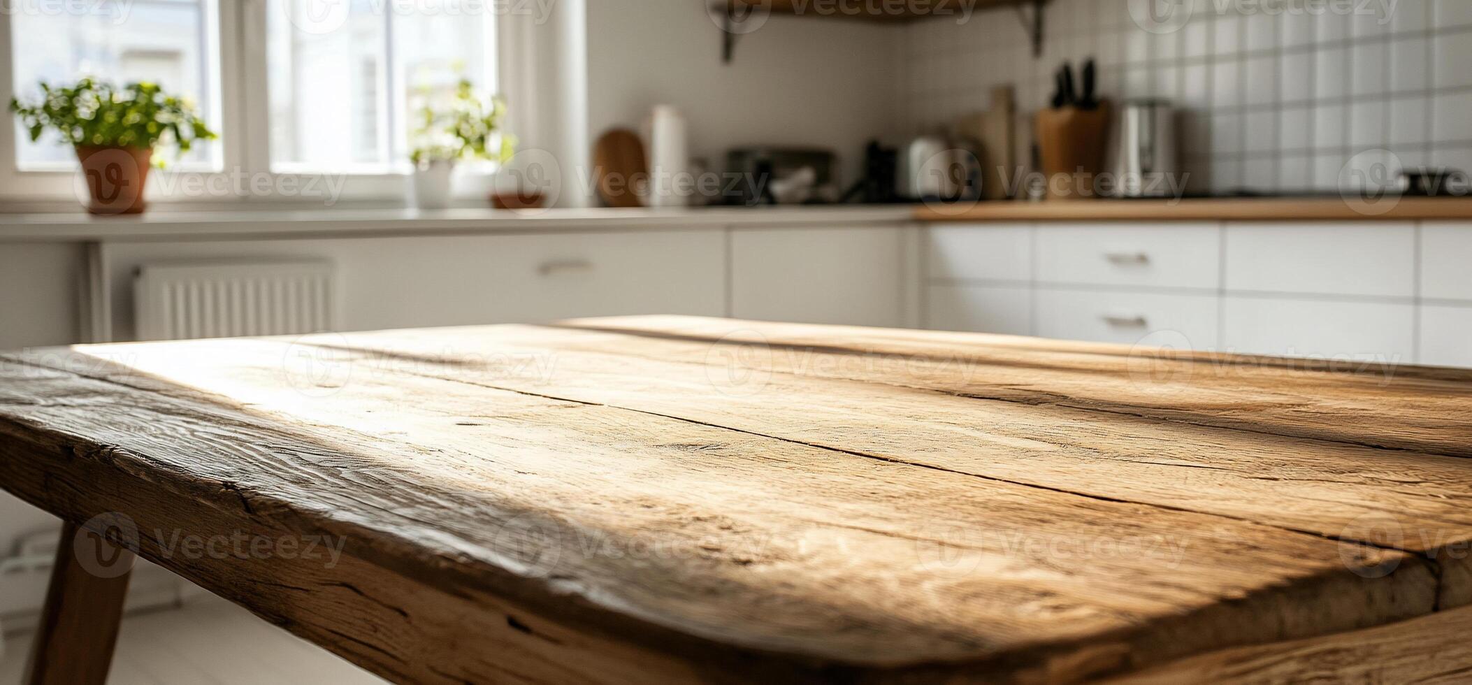 A wooden table in a kitchen with white cabinets photo