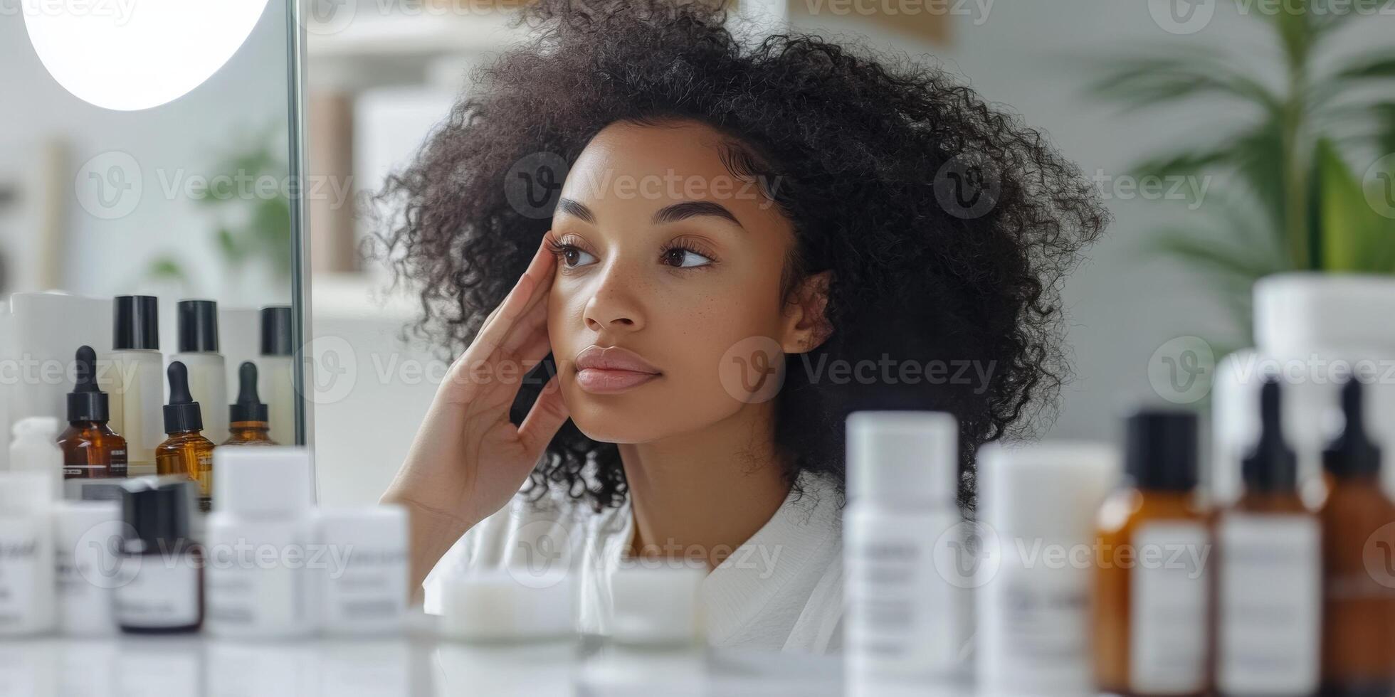 A woman looking at her face in the mirror photo