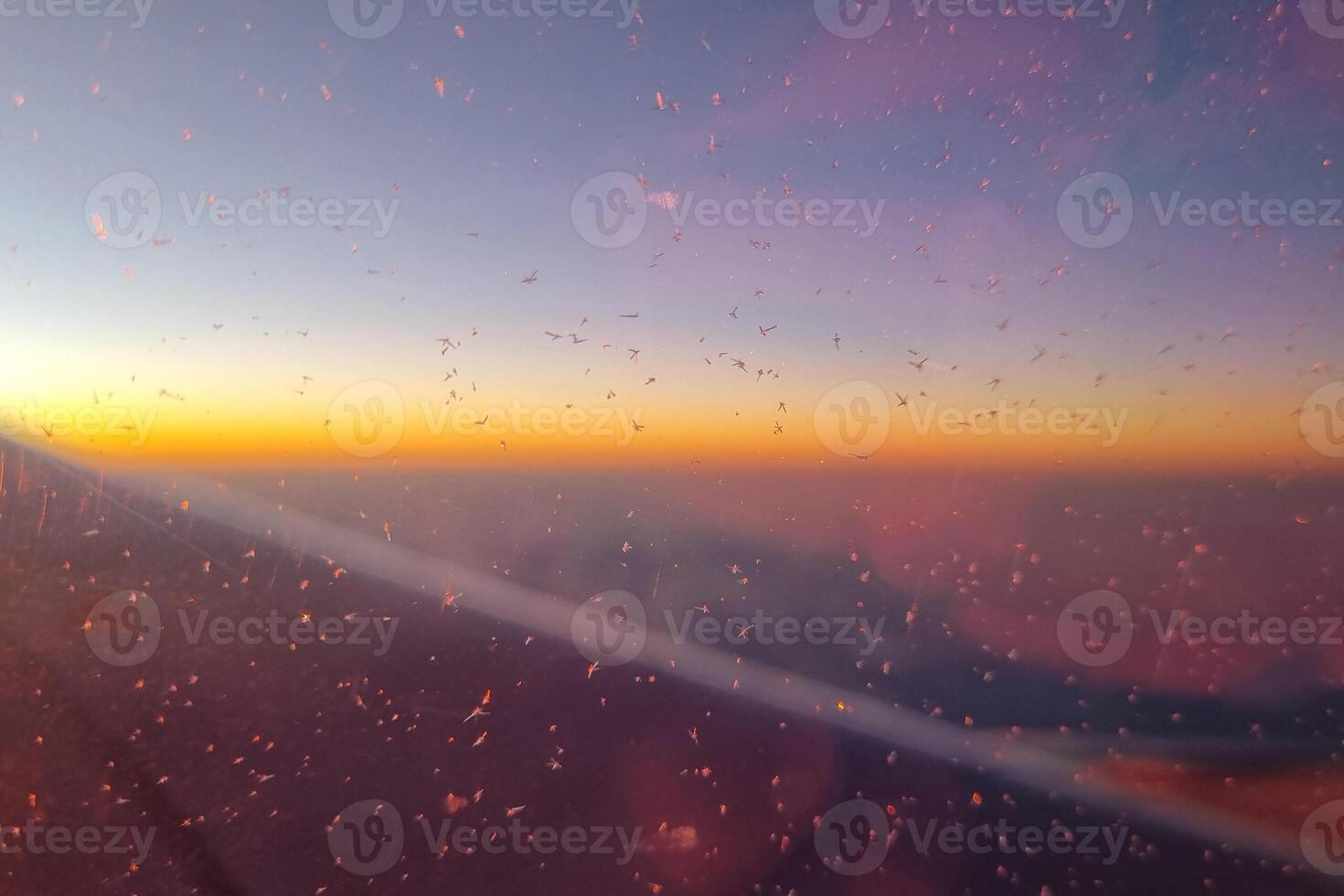 Sunset View from Airplane Window with Glowing Horizon and Ice Crystals photo