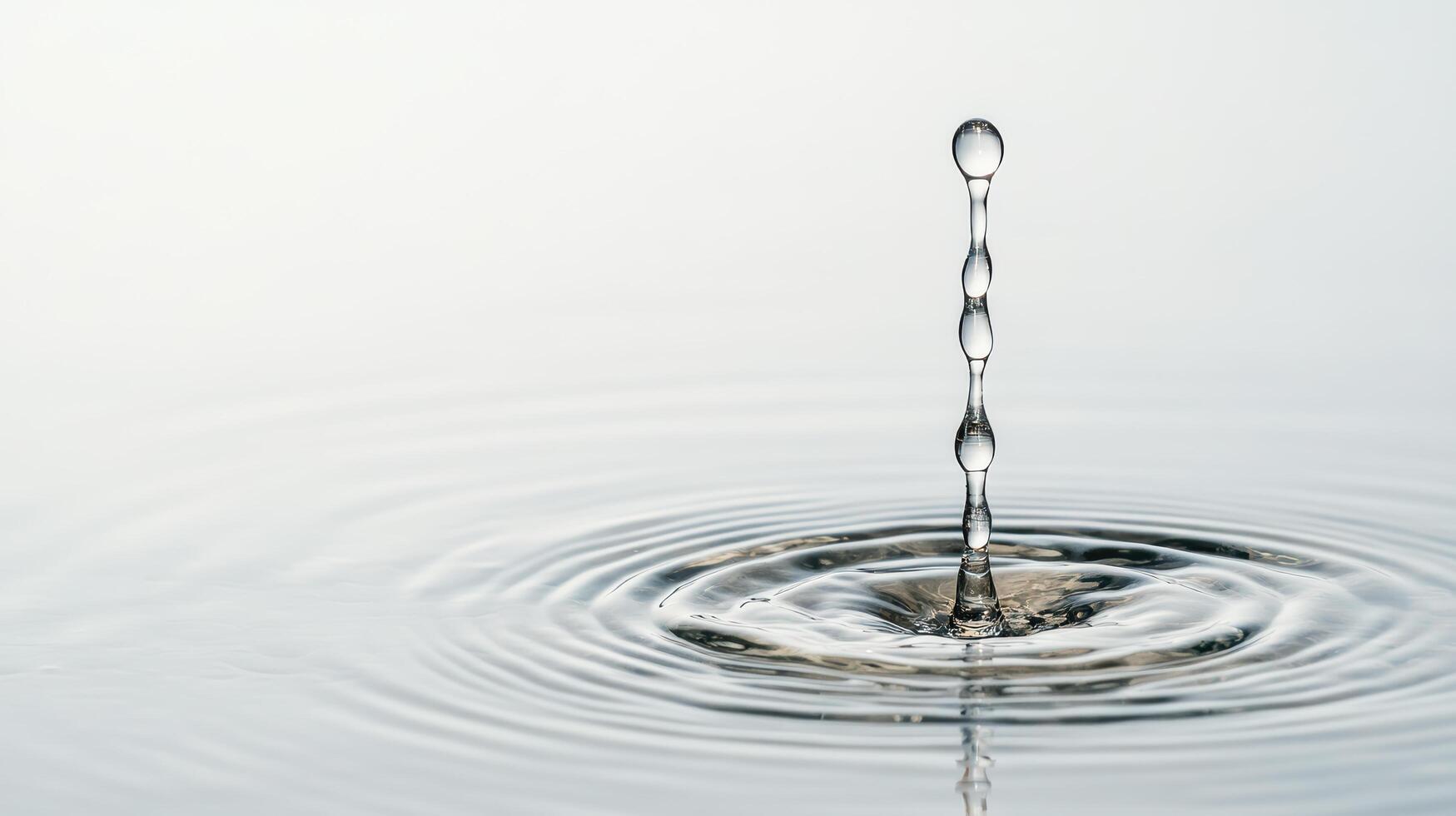 Water drop with ripple on surface of water photo