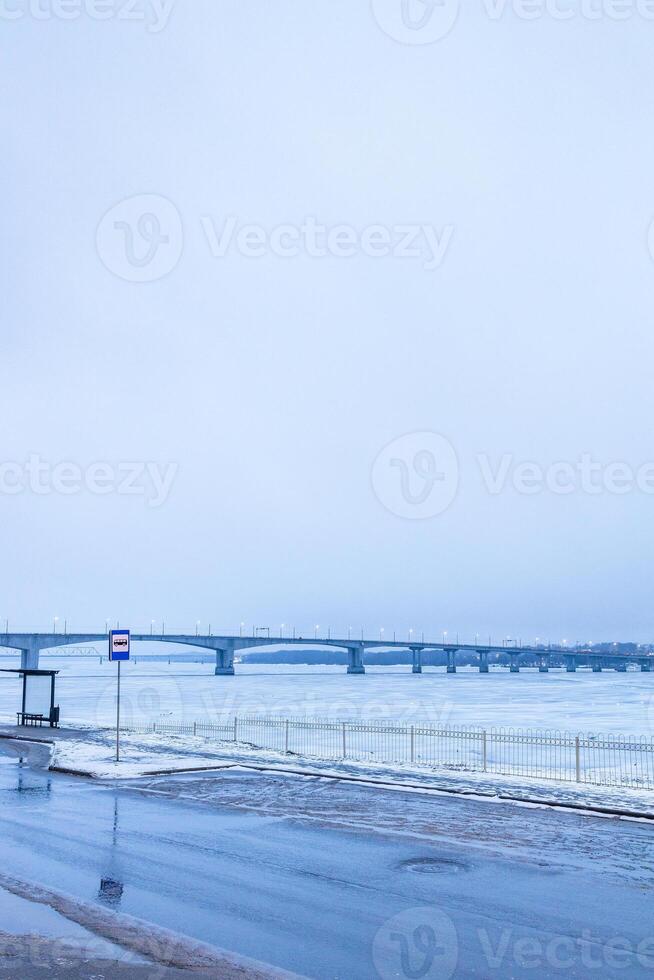 wet road at embankment of frozen river in Kostroma photo