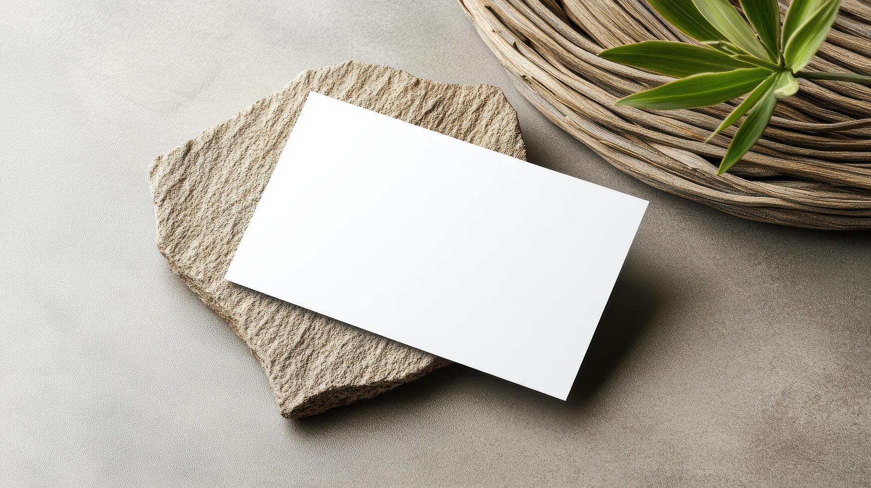 Minimalist business card on textured stone surface with greenery photo