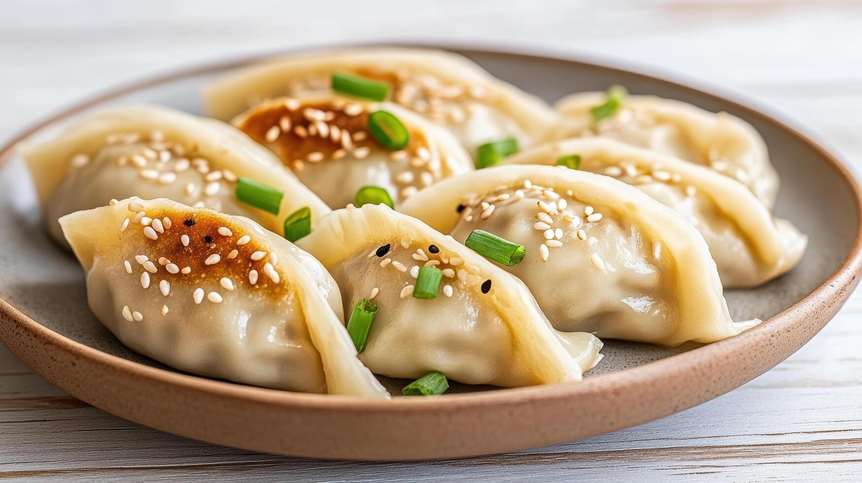 Deliciously arranged plate of freshly steamed dumplings garnished with sesame seeds and green photo