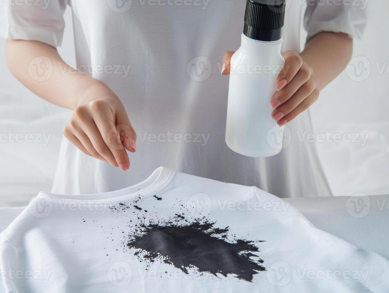 Woman applying black dye on a white t-shirt with care photo