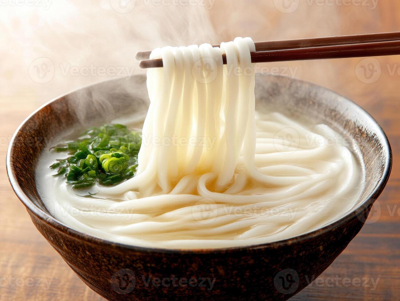 Delicious bowl of steaming noodles with green onions photo