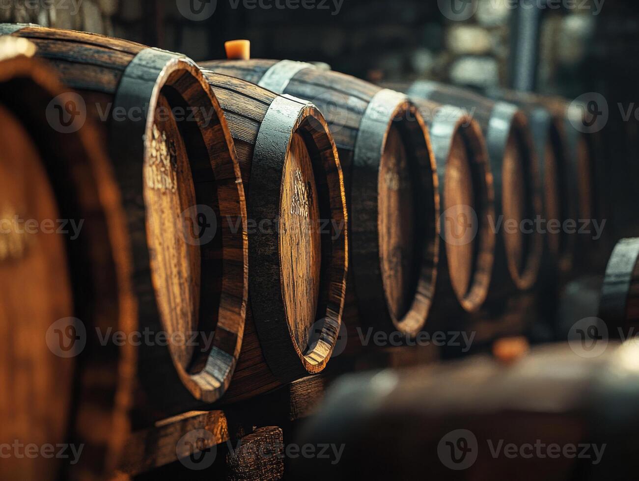 Wooden barrels lined up in a rustic cellar for aging beverages photo