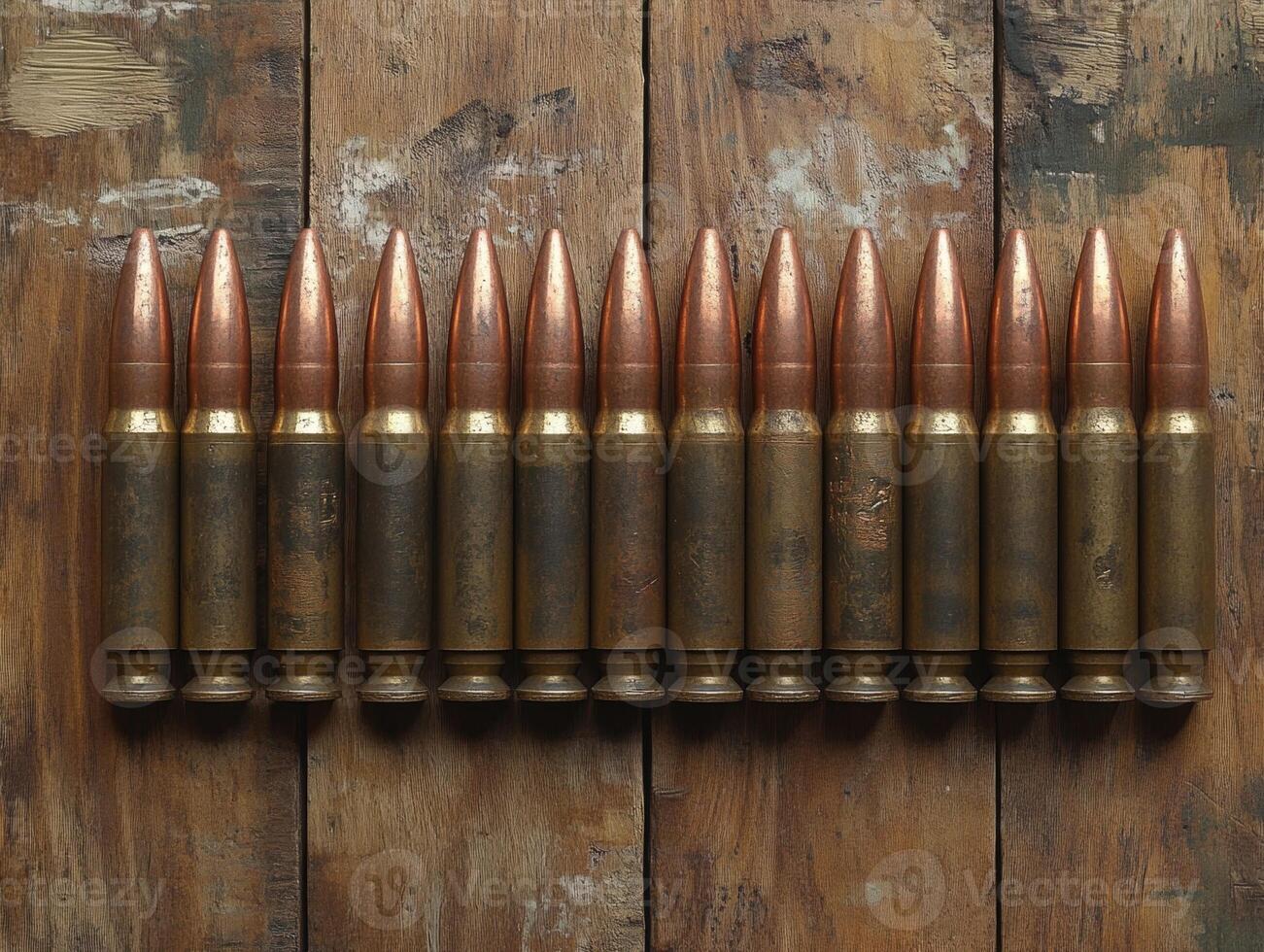 Collection of military bullets displayed on wooden surface photo