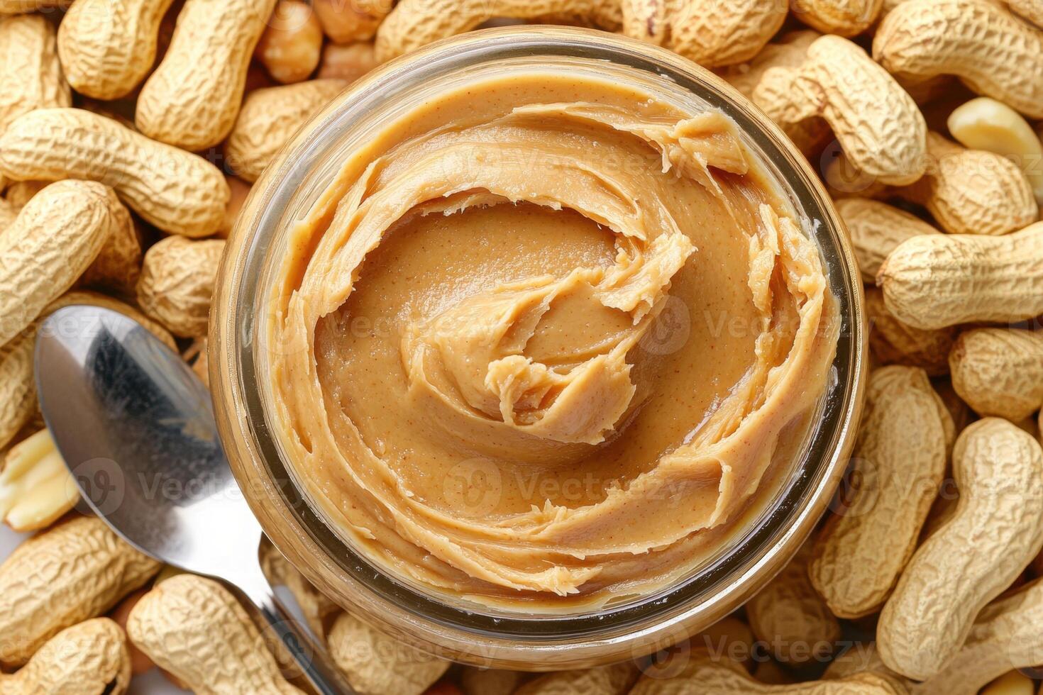 Peanut butter jar surrounded by peanuts on a wooden table photo
