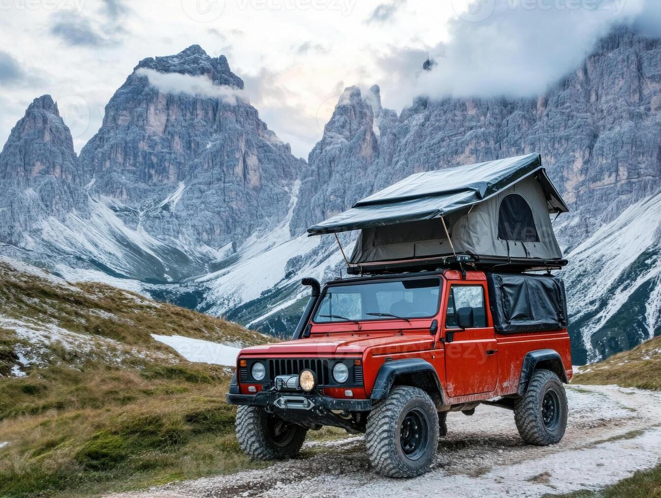 Rugged mountains with a red off-roader and rooftop tent photo