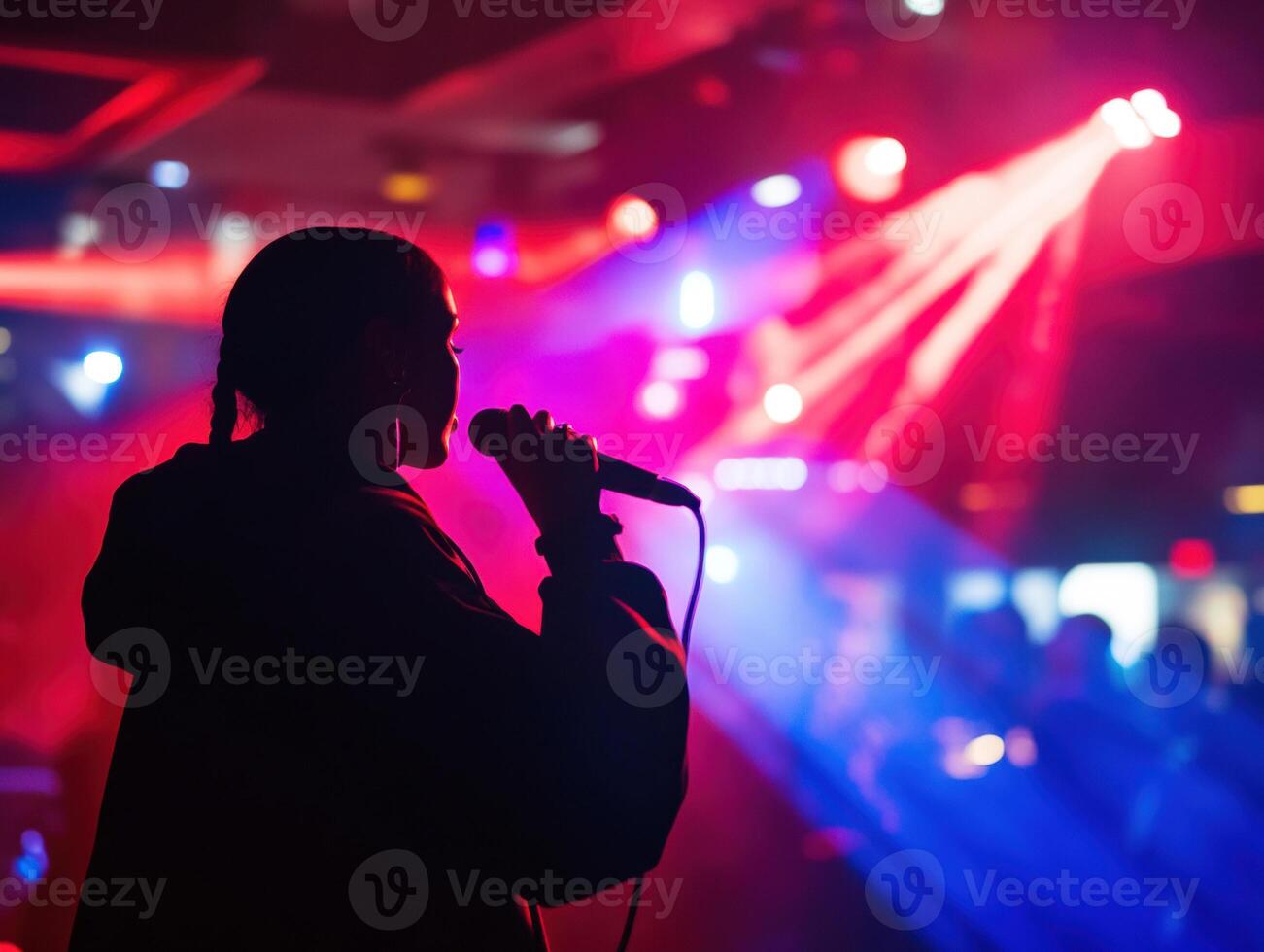 Silhouette of a singer performing in vibrant club lighting photo