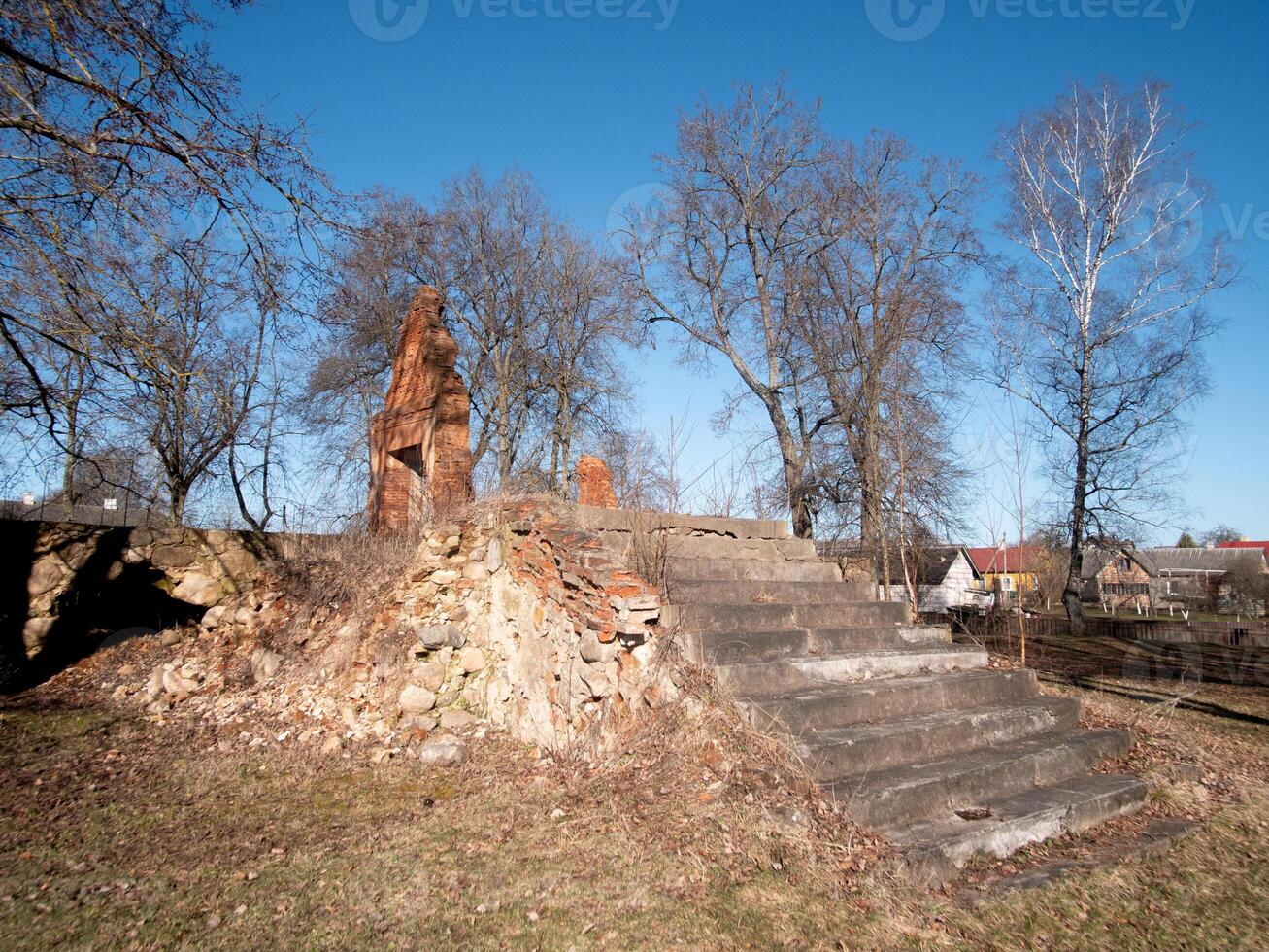 A peaceful and serene view showcasing historic ruins surrounded by lush trees beneath a clear blue sky photo