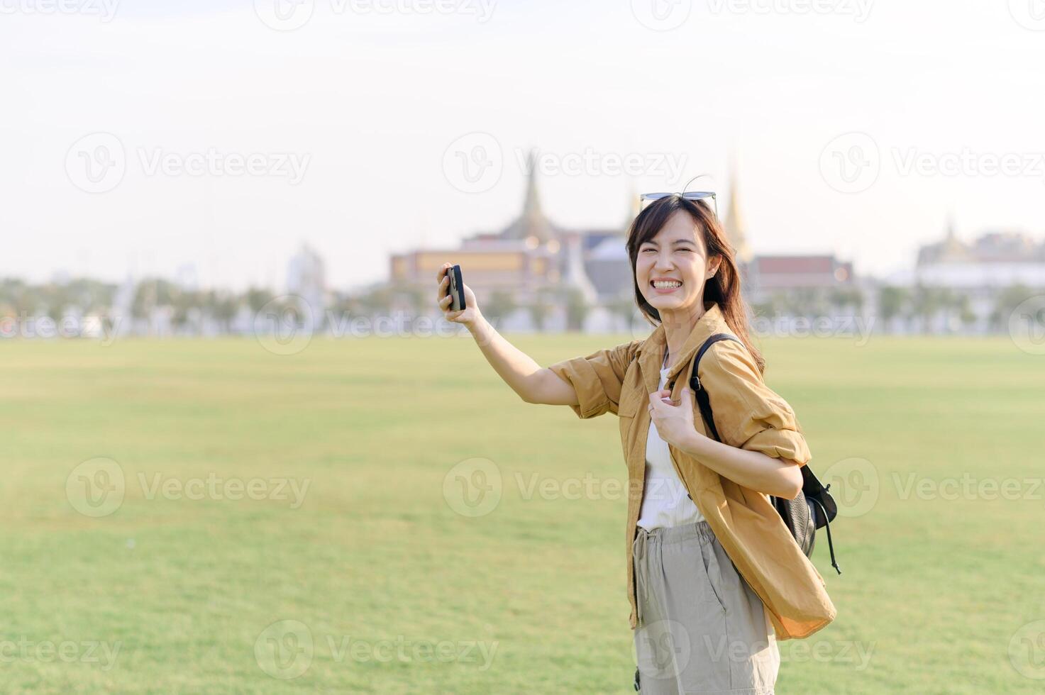 Asian woman taking selfie in front of grand palace photo