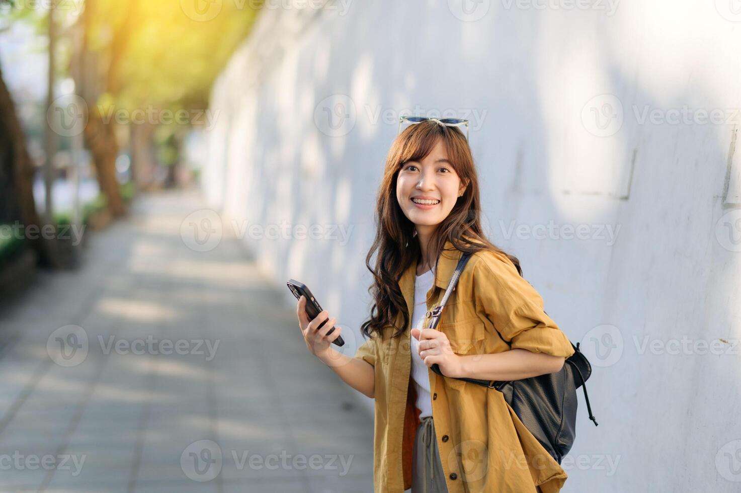 Traveler young asian woman in her 30s explores Bangkok's vibrant scene with her phone. Discover the excitement and freedom of solo adventures. photo
