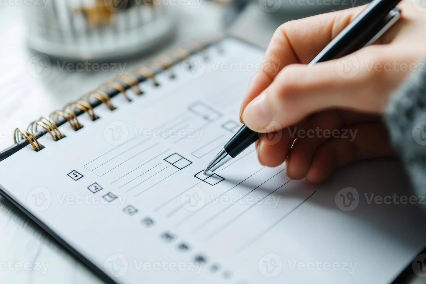 Woman checking boxes on checklist using pen in notebook photo