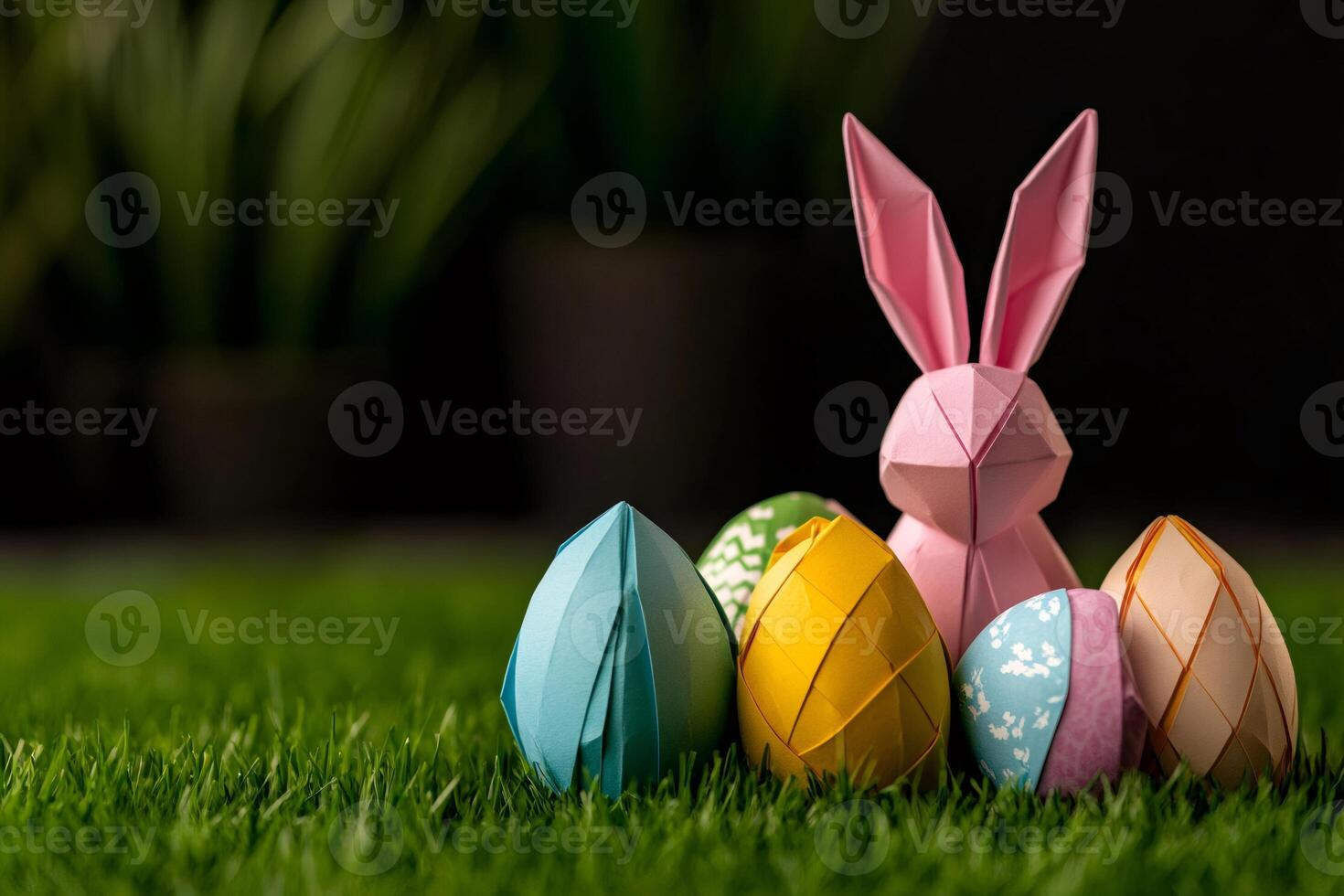 Origami easter bunny standing with colorful eggs on grass photo