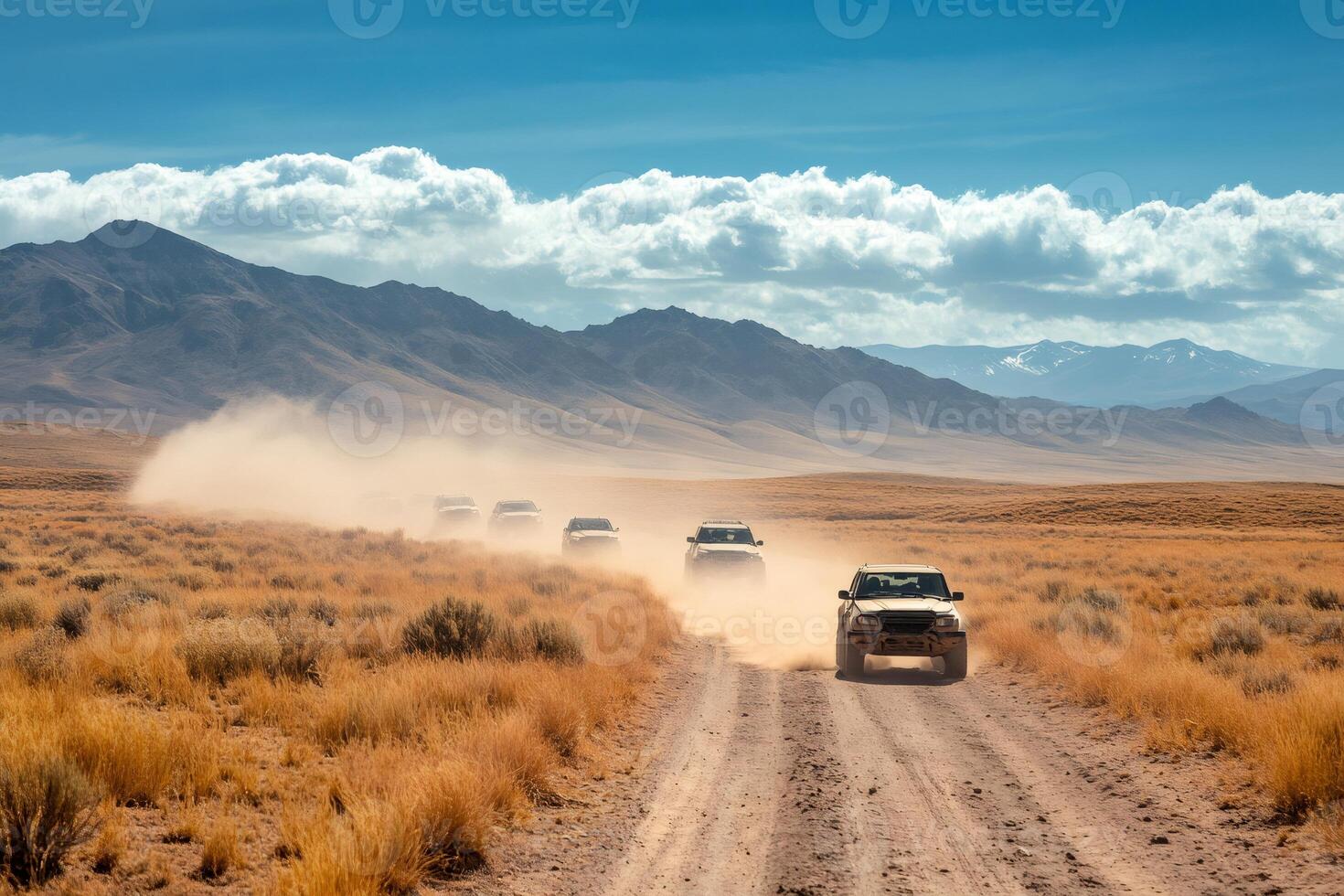 Off road vehicles leaving dust trail in desert landscape photo