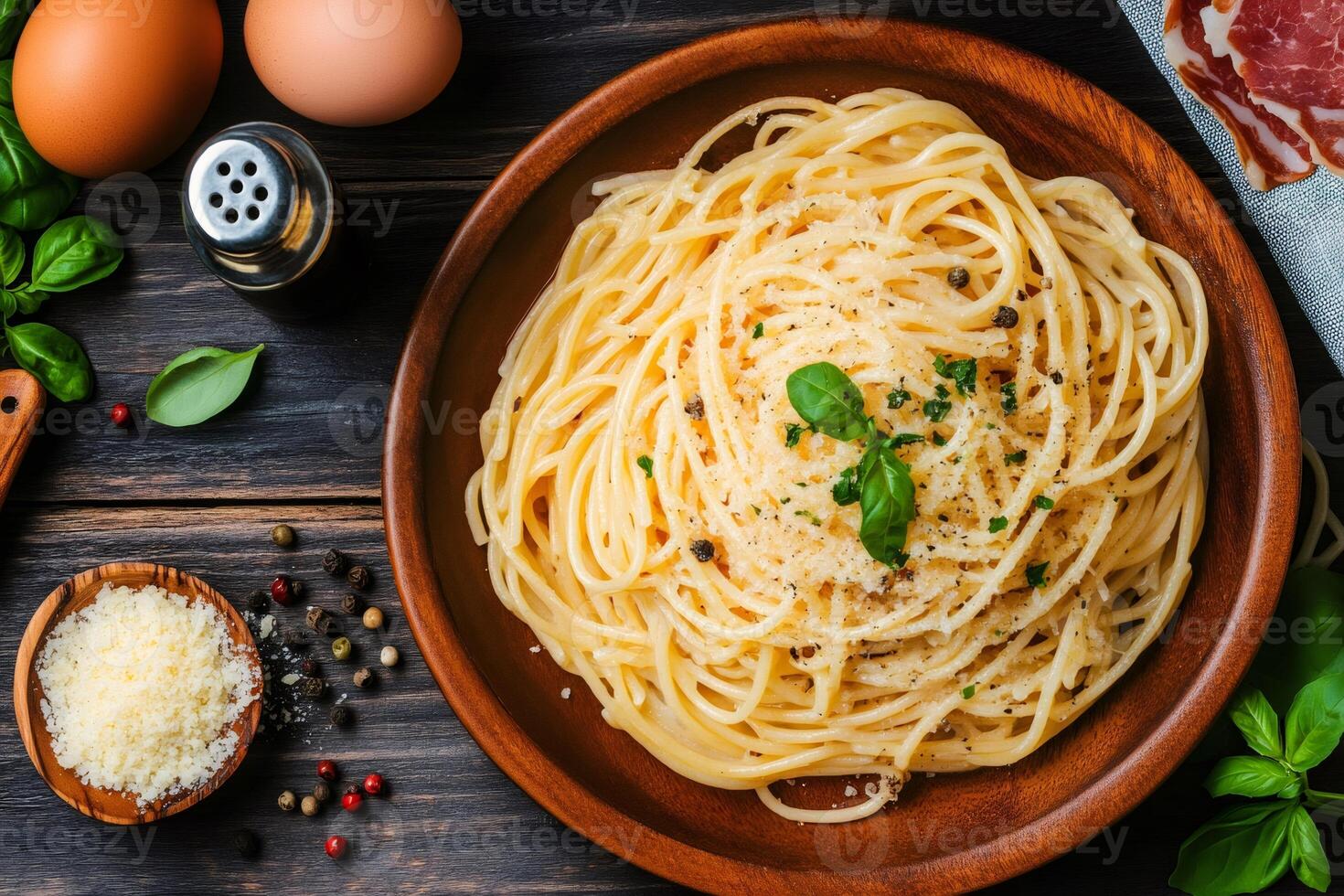 Delicious cacio e pepe with grated cheese and basil resting on wooden plate photo