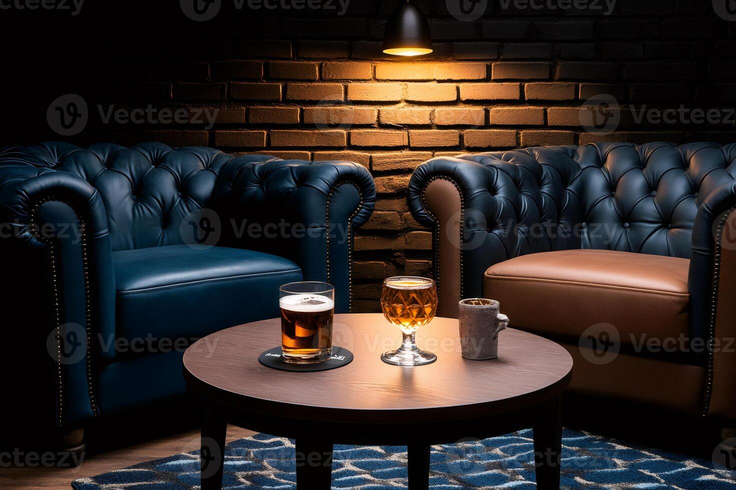 Two comfortable leather armchairs with drinks on a table illuminating a luxurious lounge bar photo