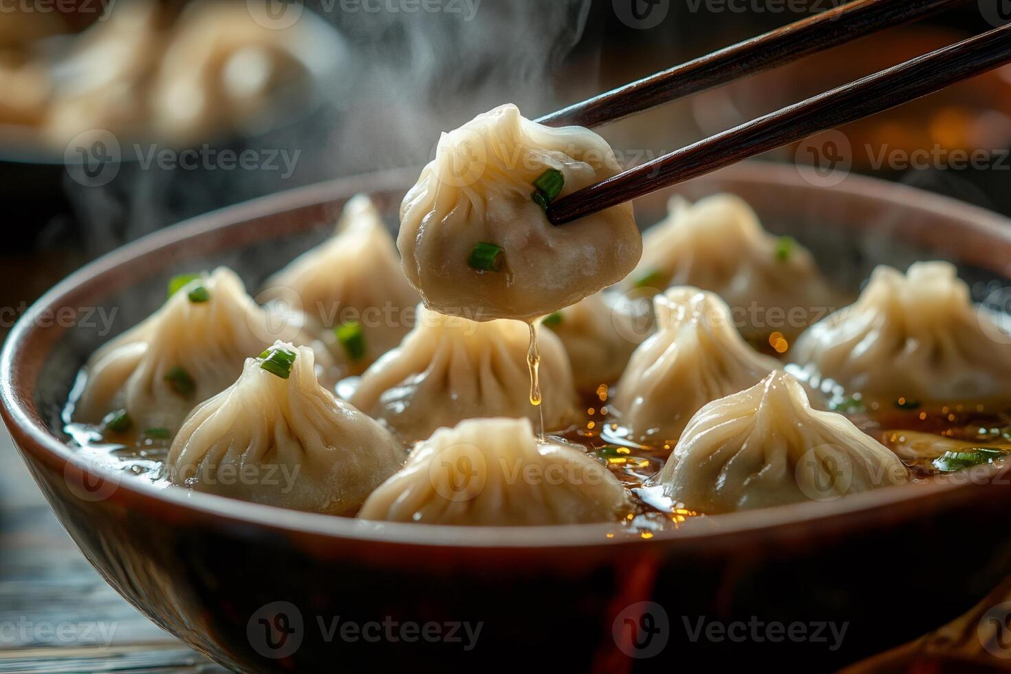 Chopsticks lifting steaming hot soup dumpling from bowl photo