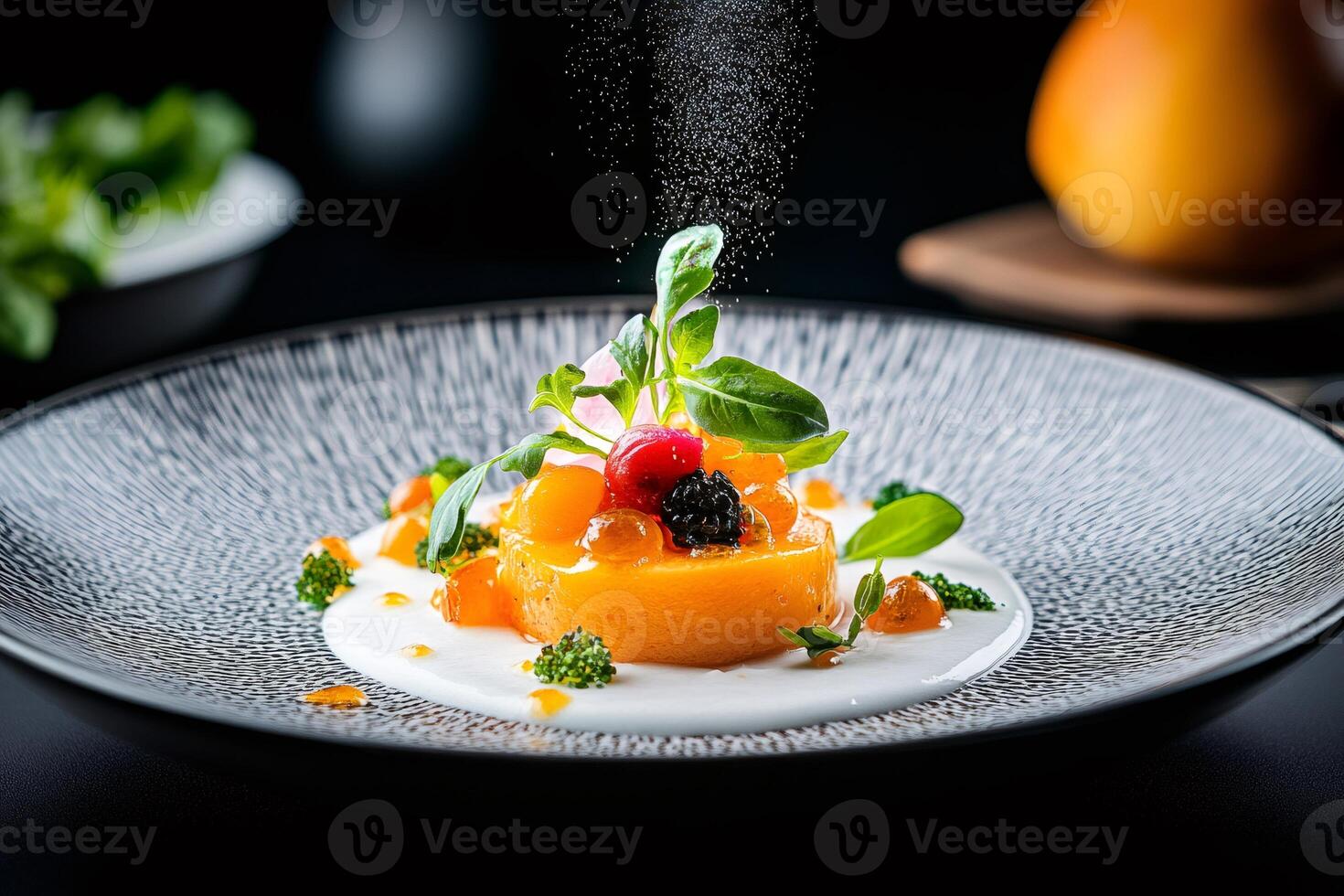 Chef sprinkling spices on gourmet dish with caviar and mango sauce photo