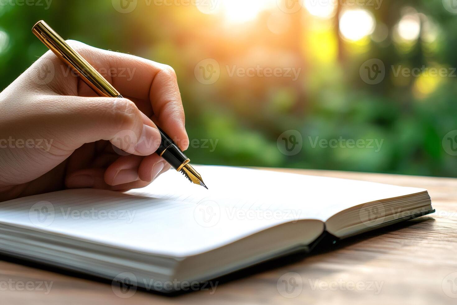 Writer using elegant fountain pen writing in notebook outdoors in nature photo