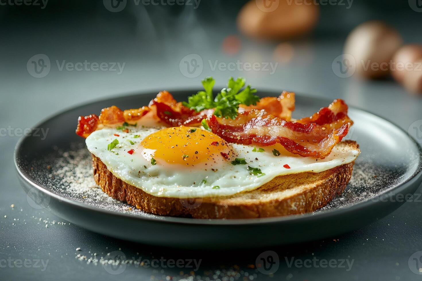 Steaming fried egg and crispy bacon on toasted bread for breakfast photo