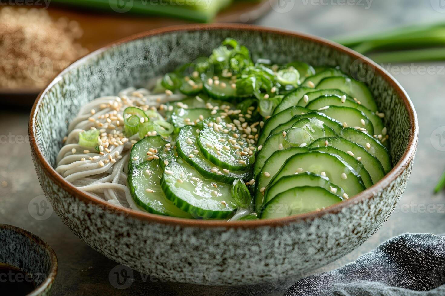 Soba noodles with sliced cucumbers and sesame seeds in rustic bowl photo