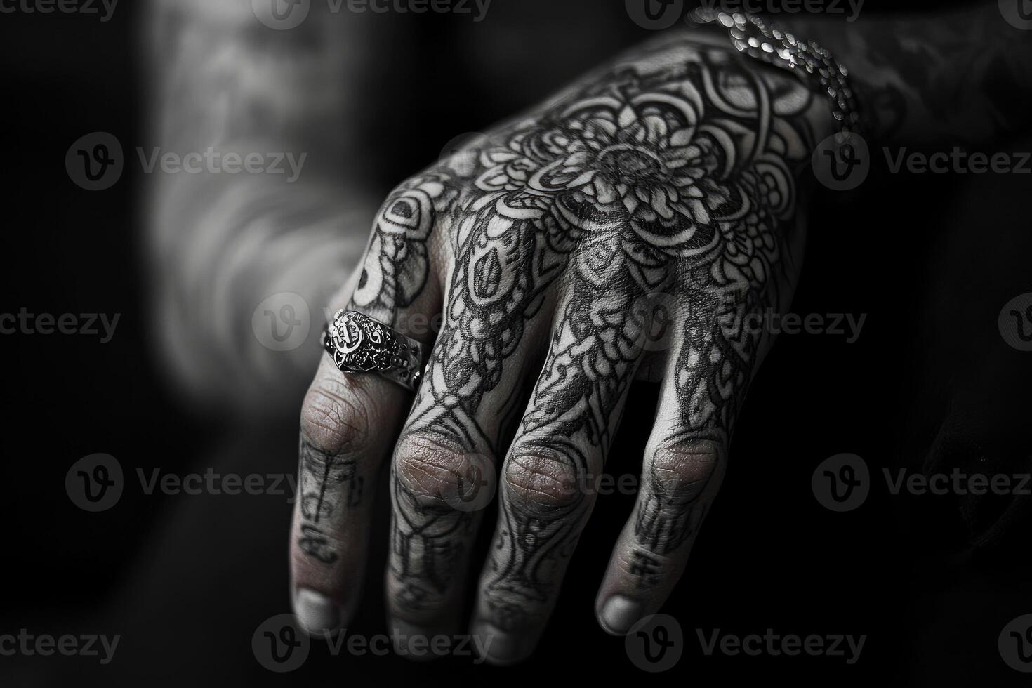 Tattooed hand showing ring and ornate floral design photo