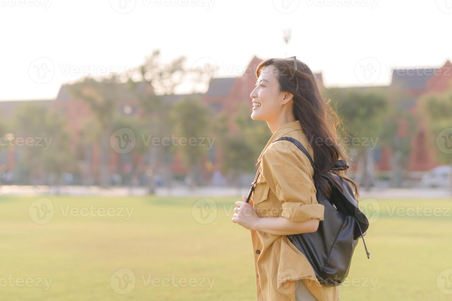A woman with a backpack walking in a field photo