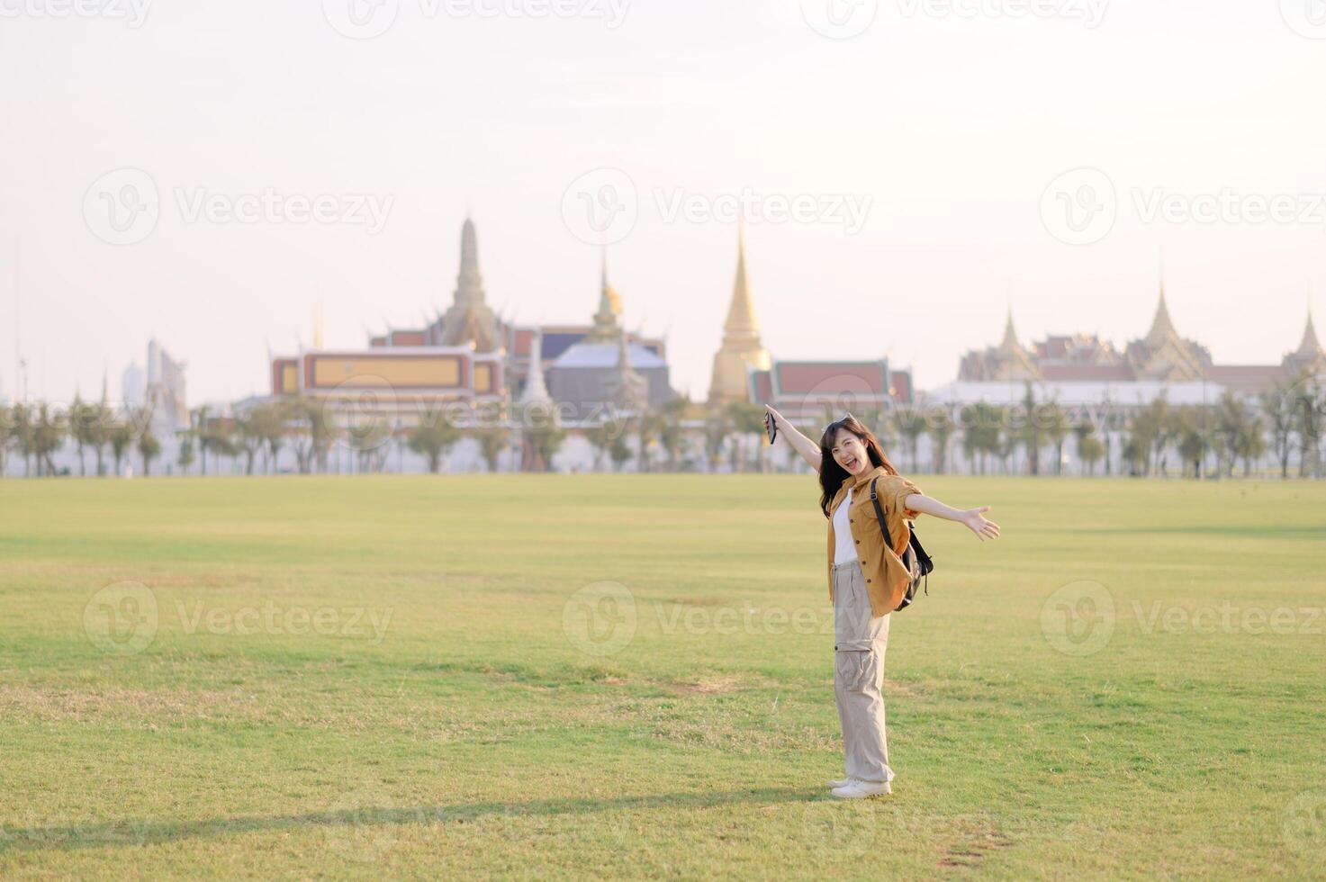 A woman standing in the middle of a field with a building in the background photo